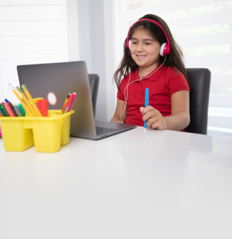 Girl with headphones talking to her teacher on a laptop